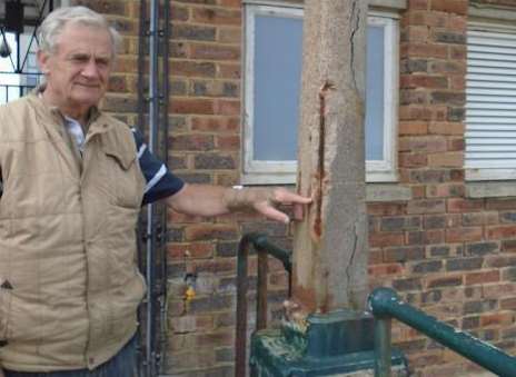 A badly corroded concrete post with ironwork support exposed