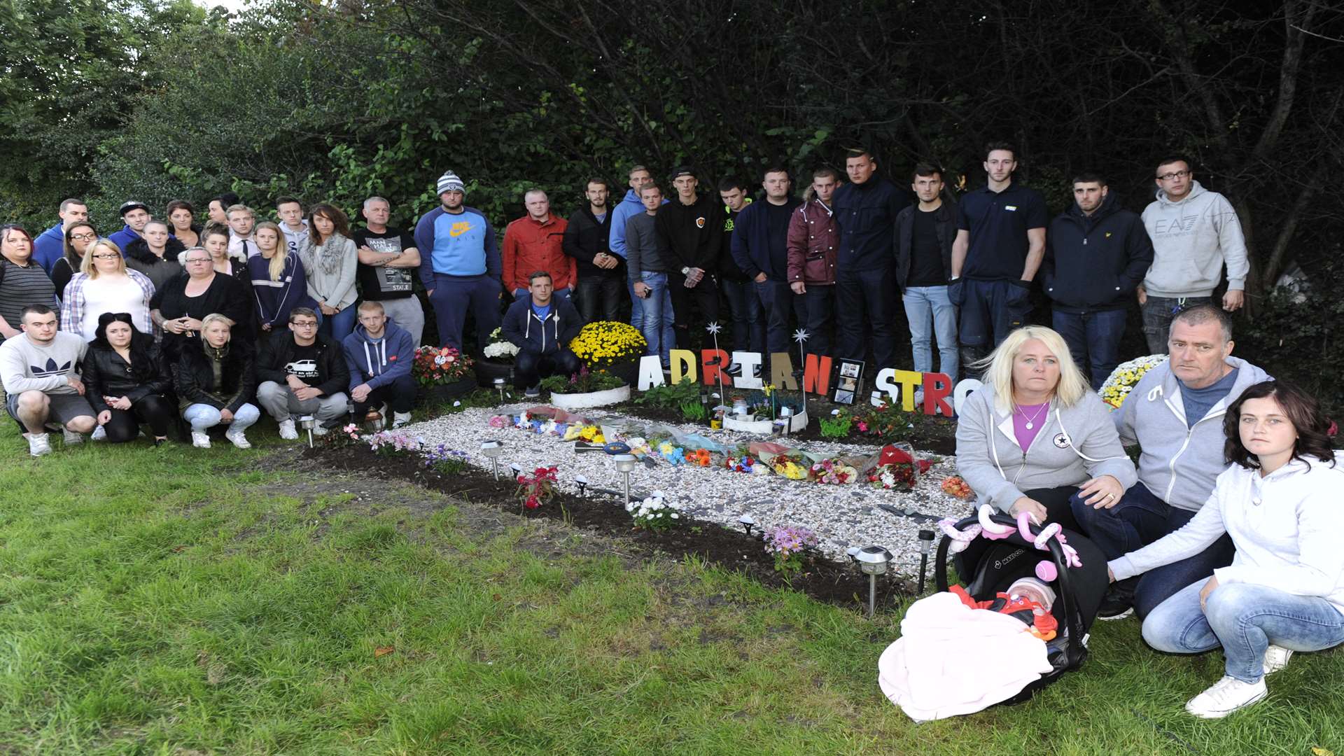 Loved ones of Adrian Stroud gather at the roadside memorial