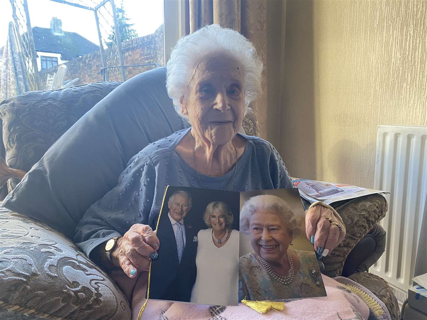 Gladys holding her two cards from Queen Elizabeth and King Charles