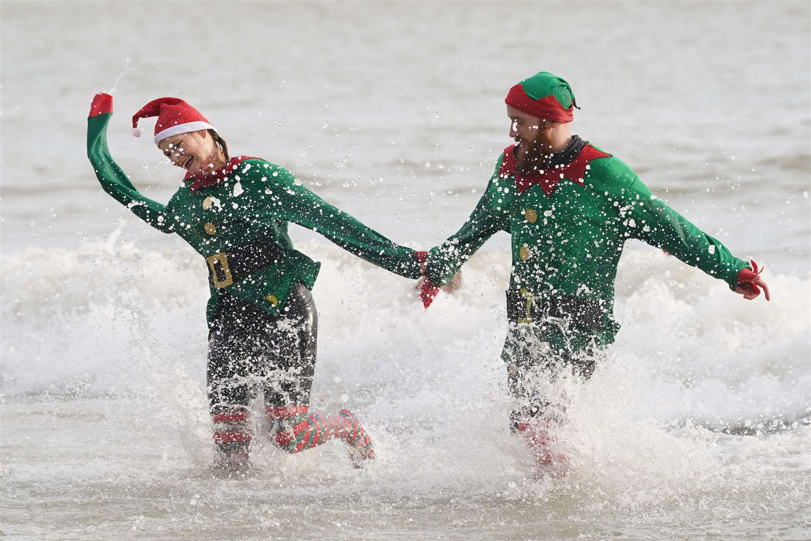 Swimmers take part in the Folkestone Lions’ Boxing Day Dip at Sunny Sands Beach in Folkestone, Kent (Gareth Fuller/PA)