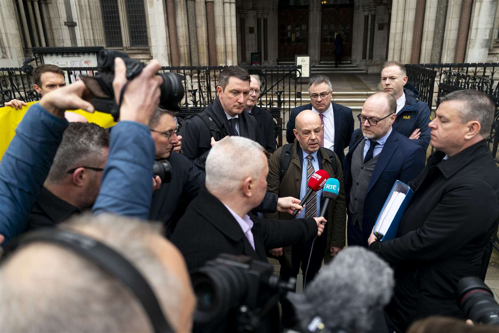 Journalists Barry McCaffrey (centre) and Trevor Birney (centre right) speak to the media outside the Royal Courts of Justice in London (Jordan Pettitt/PA)