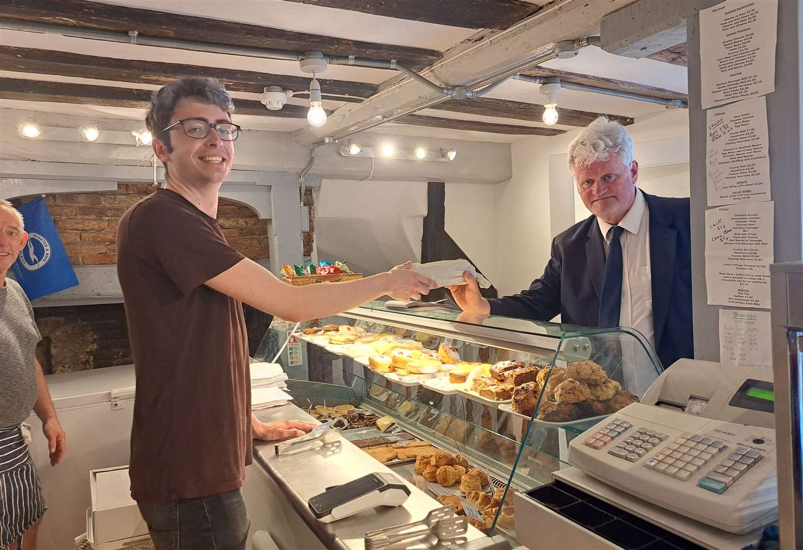 Staff member Charlie Oubridge serves reporter Sam Lennon with his daily ham salad stick