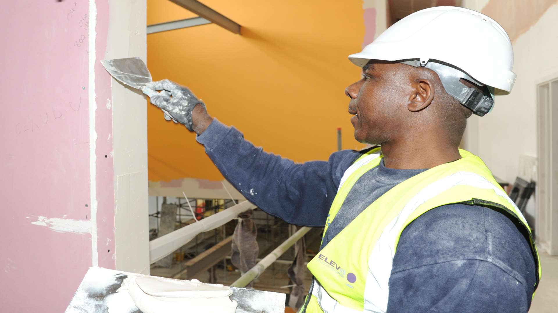 Dim Bartholomew, working for contractors Bowmer Kirkland, plasters a wall at Medway UTC