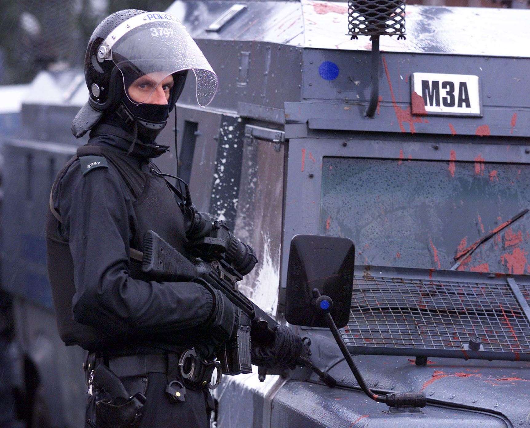 An armed policeman by his vehicle, as security was tightened for the ongoing Loyalist protest against catholic schoolchildren going to Holy Cross Primary School in North Belfast (Paul Faith/PA)