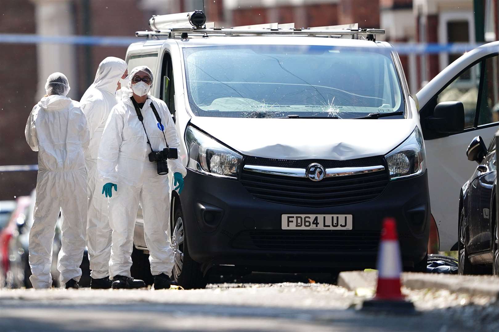 Police forensics officers search a white van (Zac Goodwin/PA)