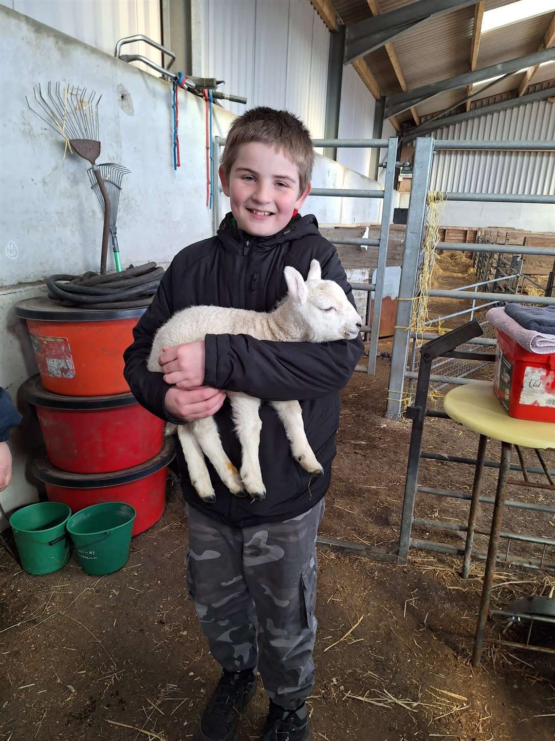 Kyle holds a baby lamb as part of work to gain one of his many badges (family handout/PA)