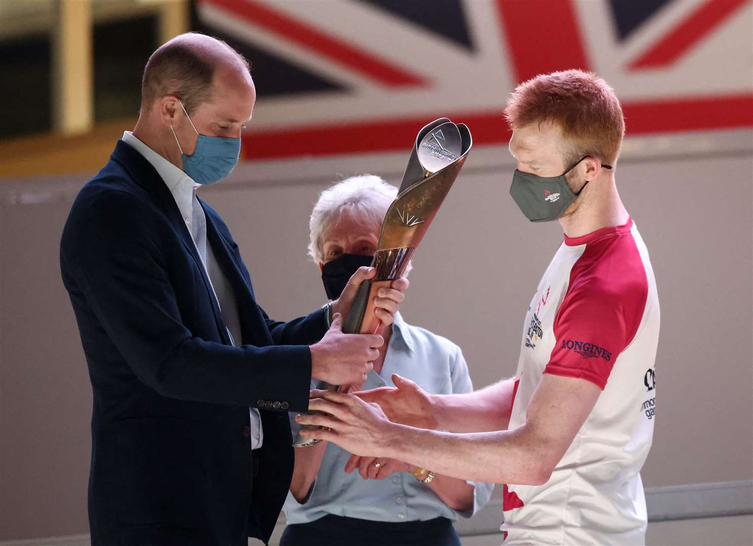 The Duke of Cambridge receives the baton from triple Olympic champion cyclist Ed Clancy. Henry Nicholls/PA