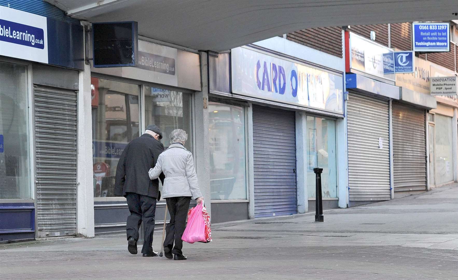 People walking past closed shops (Martin Rickett/PA)