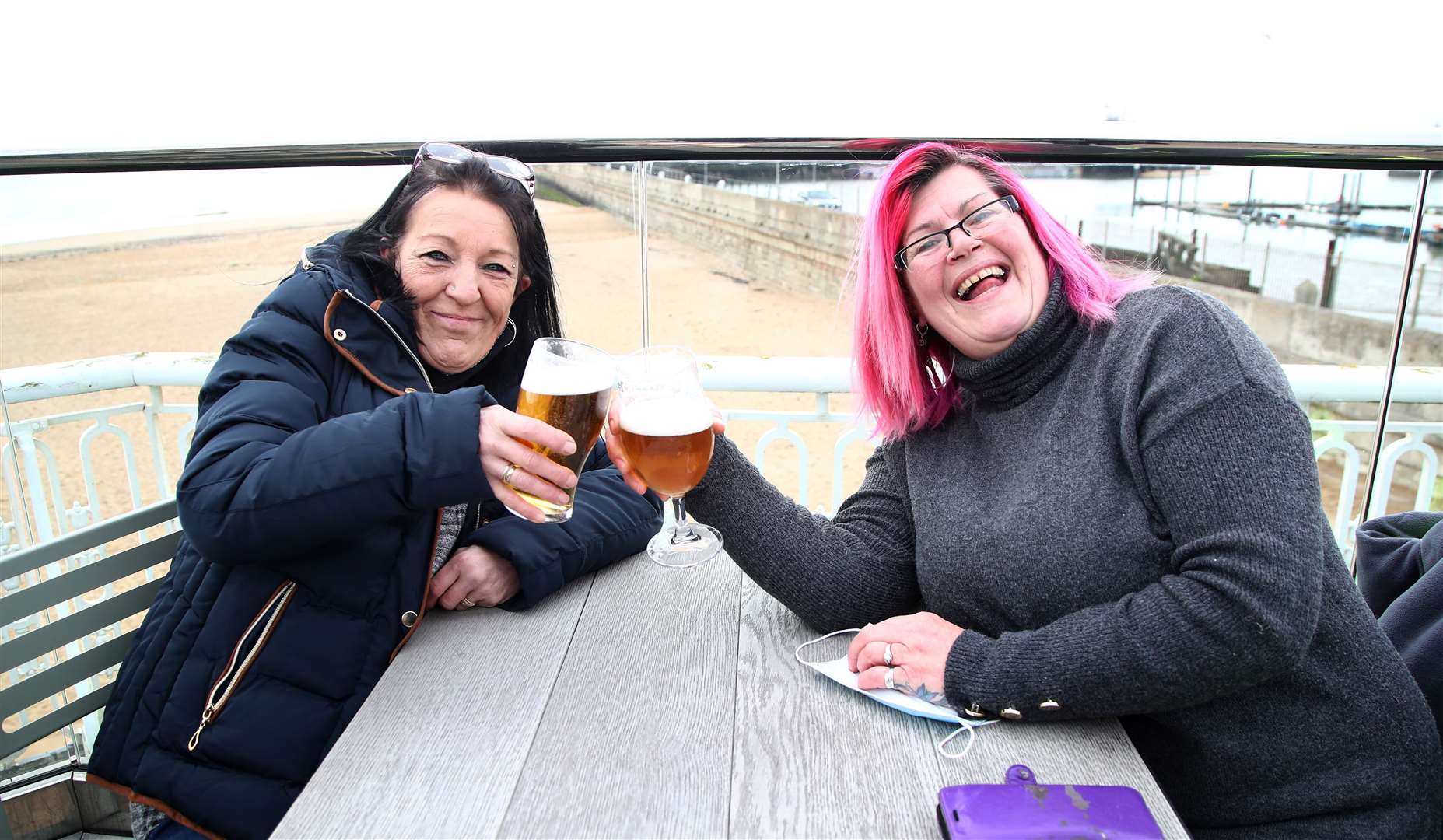 Friends Sue Bell (left) and Pippa Ingram with their drinks after being the first customers back into the Royal Victoria Pavilion in Ramsgate, Kent (Gareth Fuller/PA)