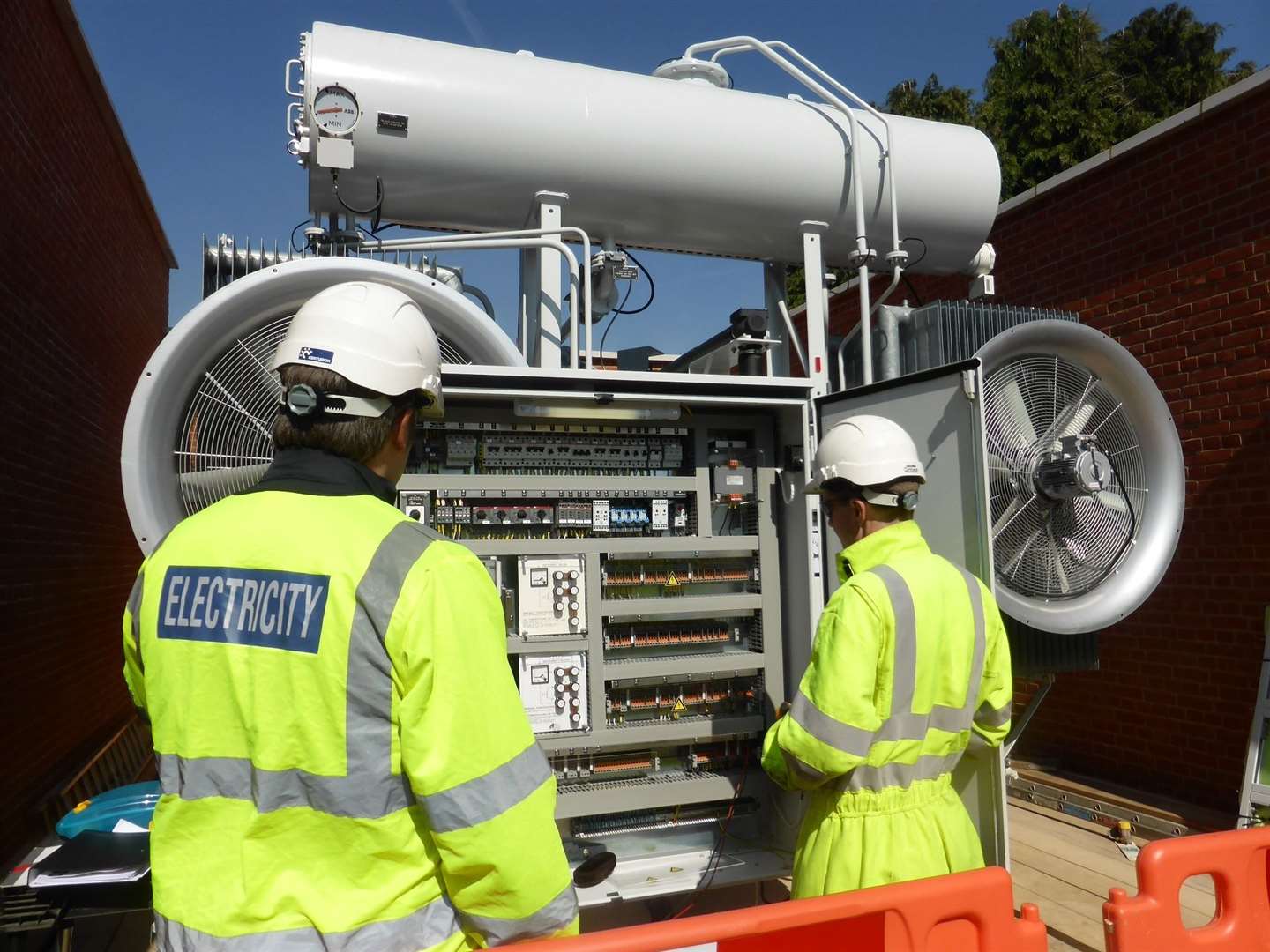 A new 42-tonne transformer is delivered to UK Power Networks’ substation in Maidstone as part of a £5.1m electricity upgrade. Project manager, Duncan Smith, withcommissioning engineer, Ed Spalding, by the transformer control cubicle. (10875815)