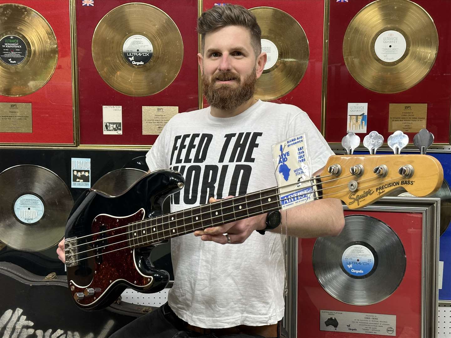 Auctioneer Luke Hobbs with Chris Cross’s Live Aid bass guitar (Gardiner Houlgate/PA)