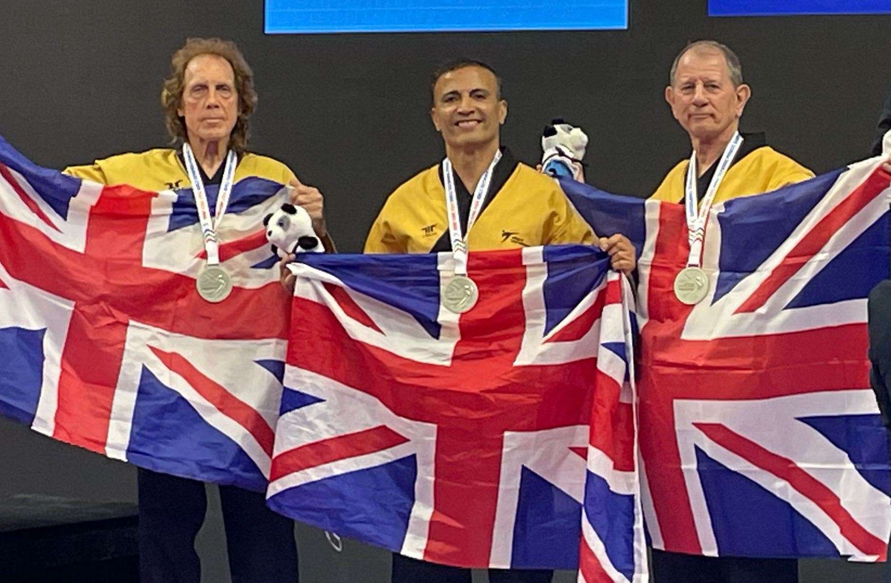 Ashford's Colin Larkin, right, with his GB team-mates Michael Pejic, left, and Ali Pourtaheri after winning silver at the World Taekwondo Championships in Hong Kong