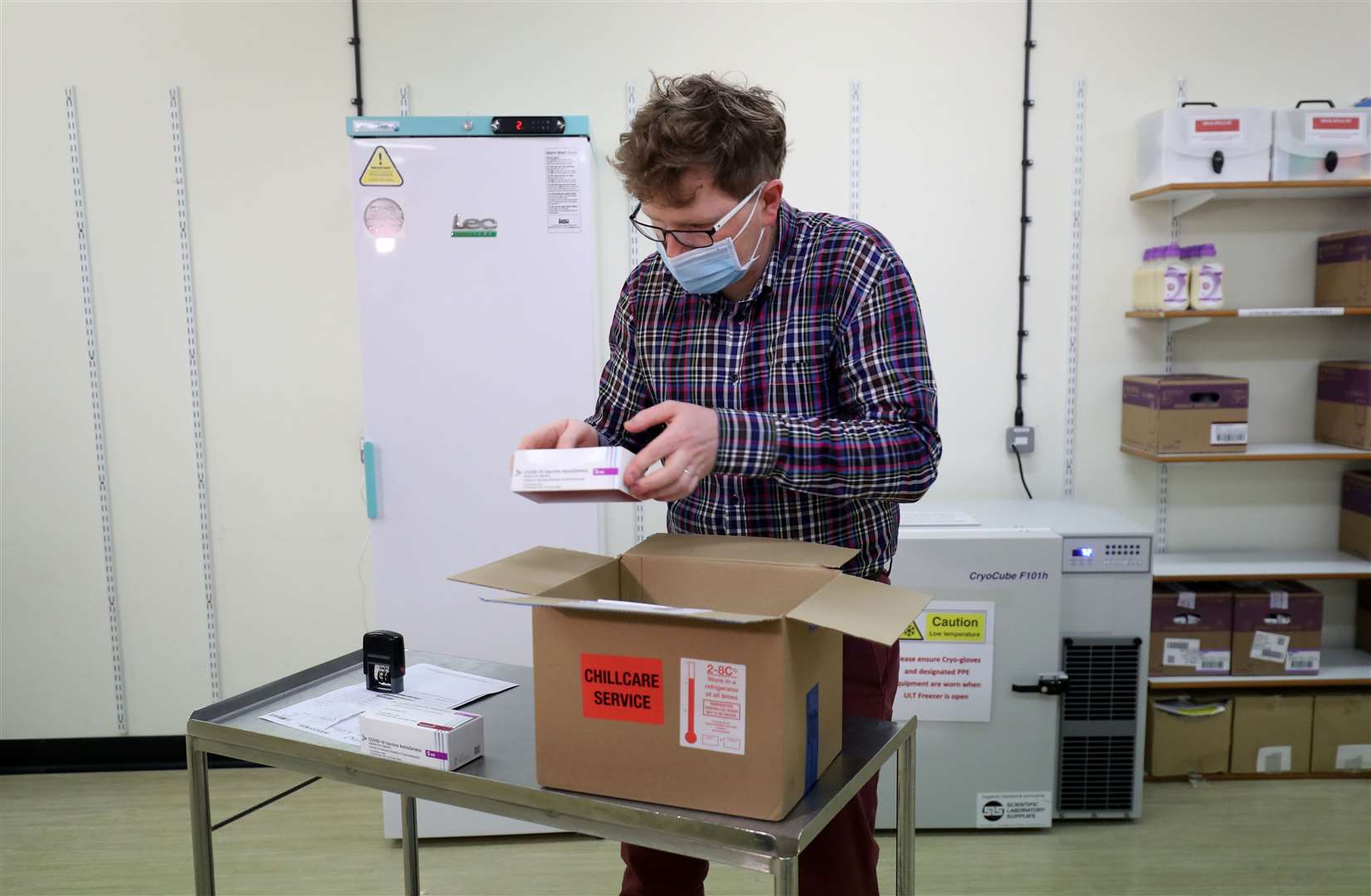 Assistant technical officer Lukasz Najdrowski unpacks doses of the Oxford University/AstraZeneca Covid-19 vaccine as they arrive at the Princess Royal Hospital in Haywards Heath, West Sussex (Gareth Fuller/PA)