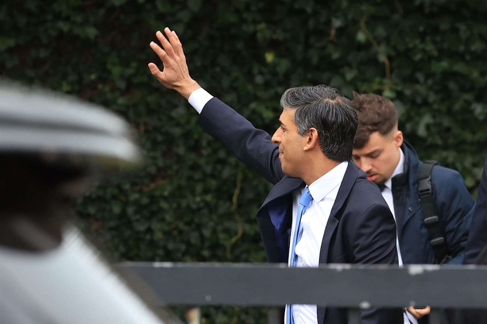 Prime Minister Rishi Sunak waving to members of the public as he visits Glencraig Integrated Primary School (Liam McBurney/PA)