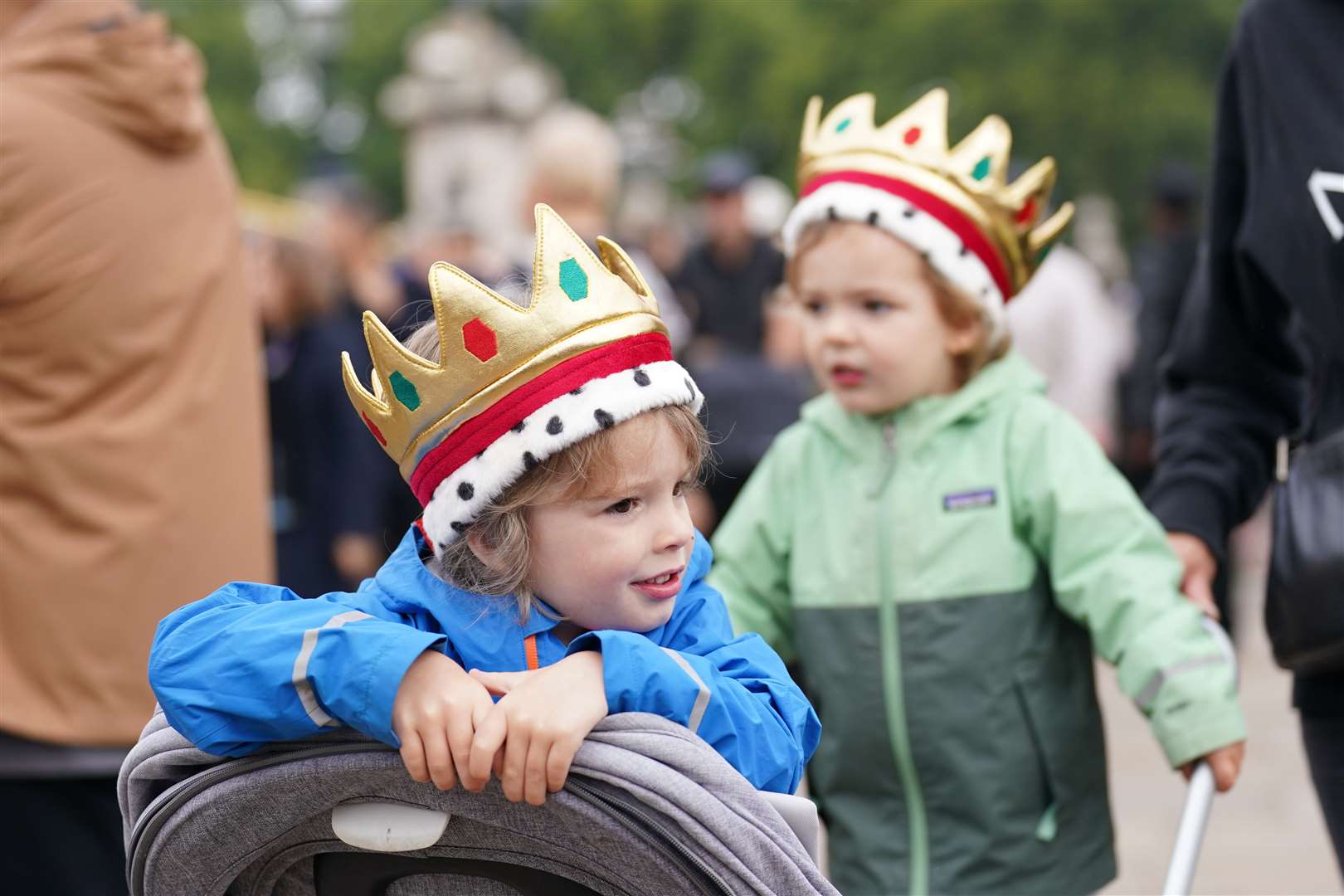 Two young children play outside Buckingham Palace (Kirsty O’Connor/PA)