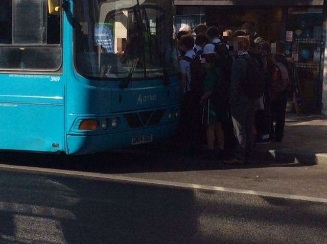 Pupils crowd round a bus in Maidstone meaning social distancing is difficult