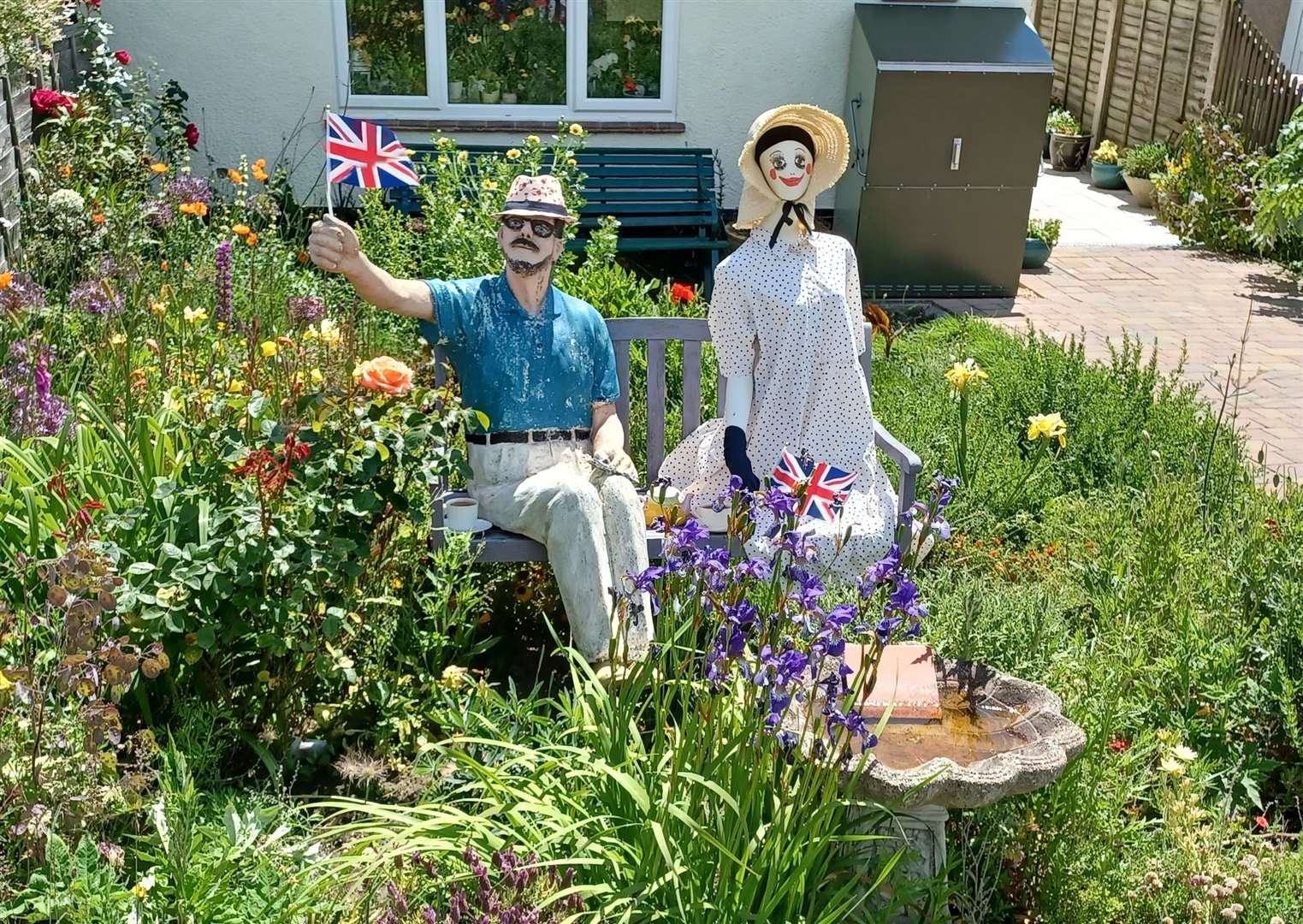 An eerily lifelike scarecrow raises a Union Flag