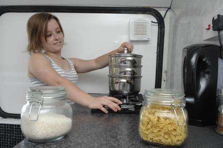 Stacey Drinkwater in the kitchen transformed by partner Daniel Bond in a double decker bus.