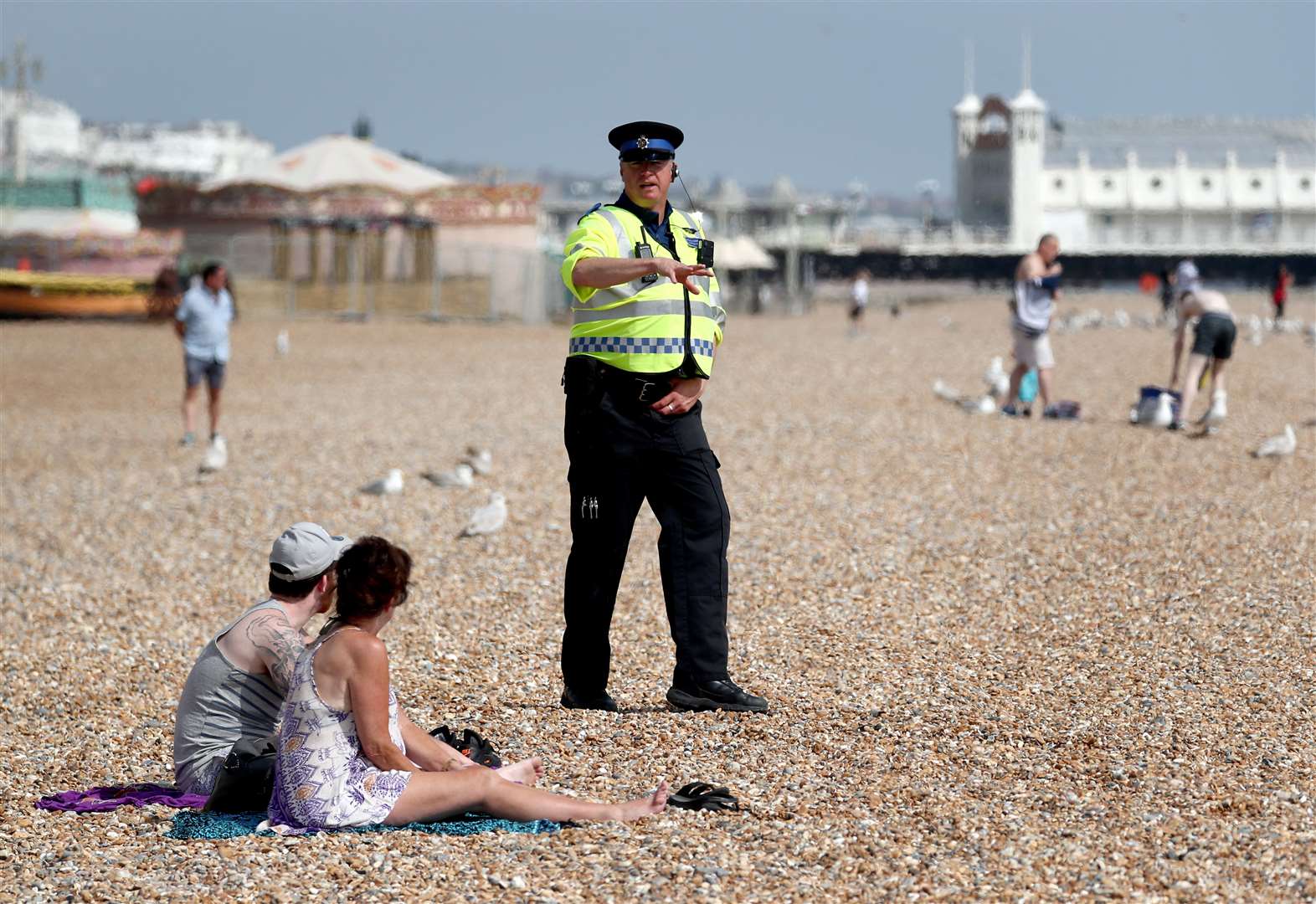 A police officer advises people to leave Brighton beach on May 9 (Gareth Fuller/PA)