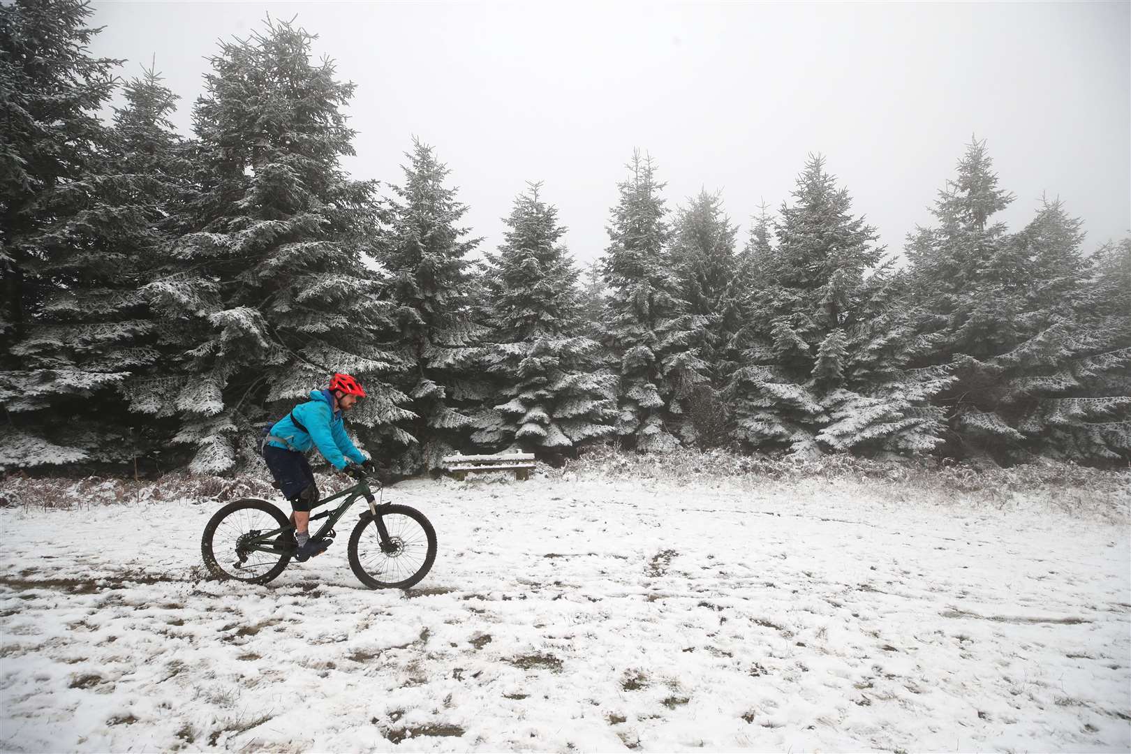 A man cycles through the snow in Mortimer Forest near Ludlow in Shropshire (Nick Potts/PA).