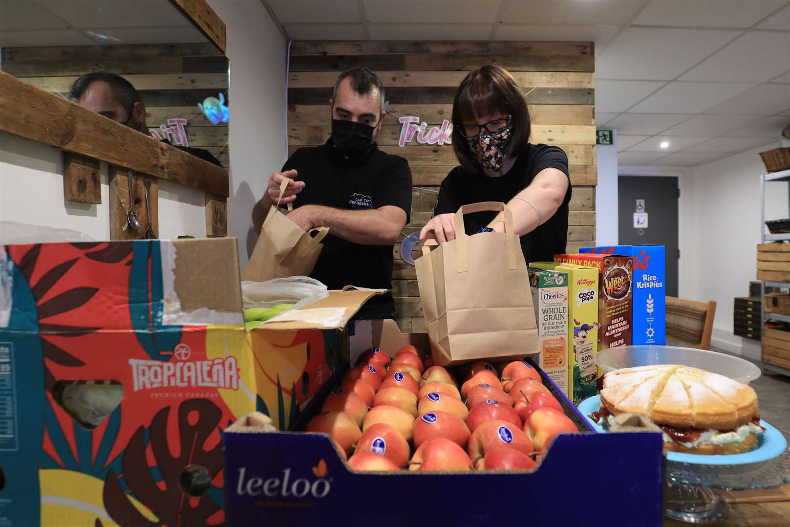 Dawn Grain (right) manager of the Rumour Cafe in Sheerness Kent, is assisted by local business owner, Danny Chamberlain, as she prepares bags containing free meals for distribution to children (Gareth Fuller/PA)