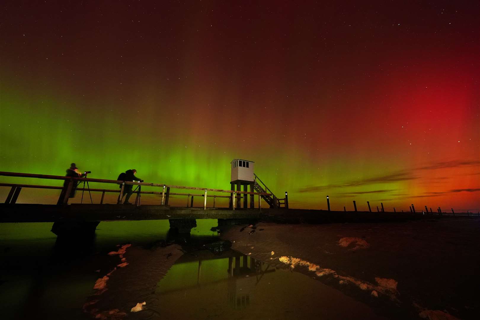 Here, a refuge hut on the causeway to Holy Island in Northumberland gives a sense of the display’s majestic scale (Owen Humphreys/PA)