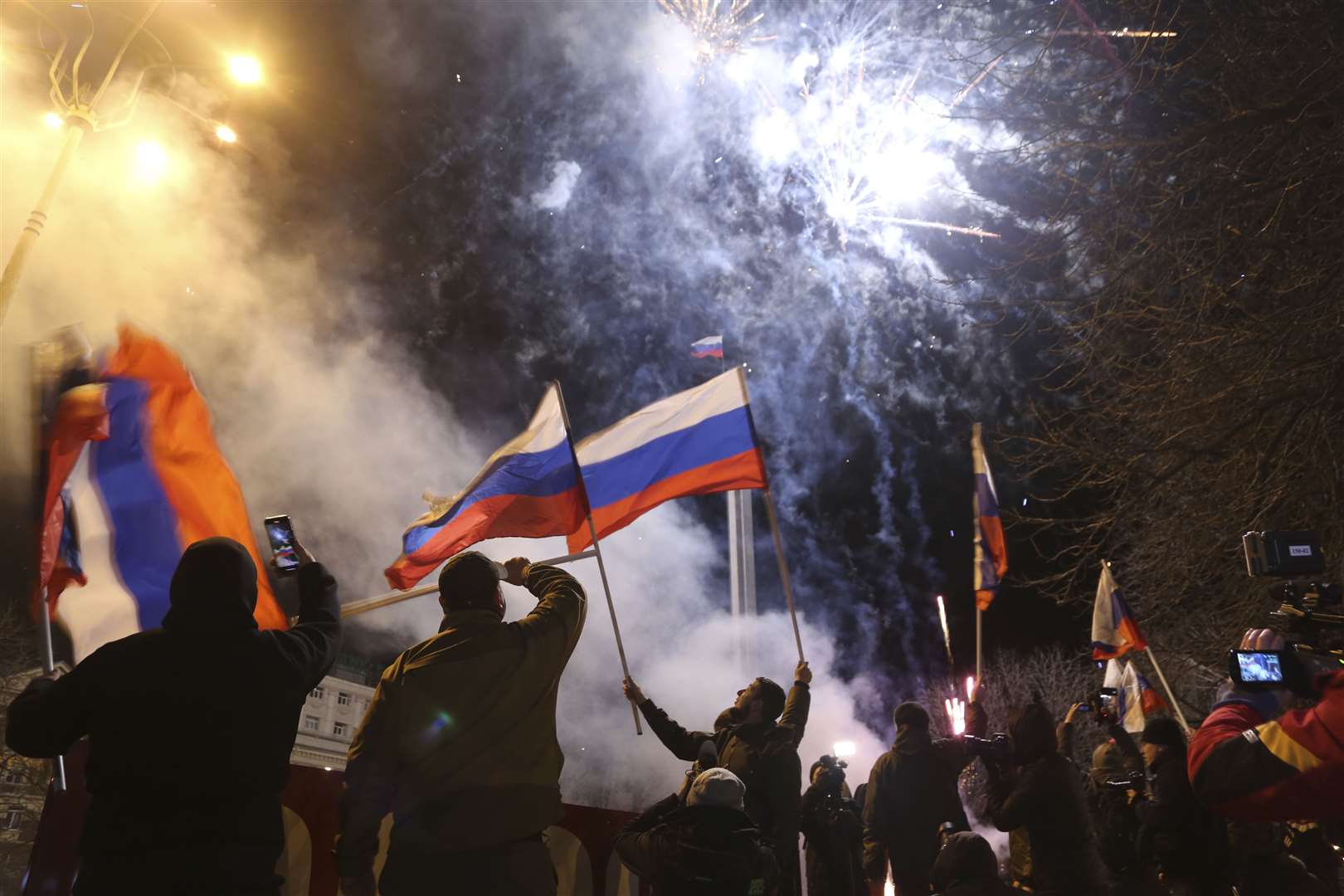 People waving Russian flags in Donetsk (Alexei Alexandrov/AP)