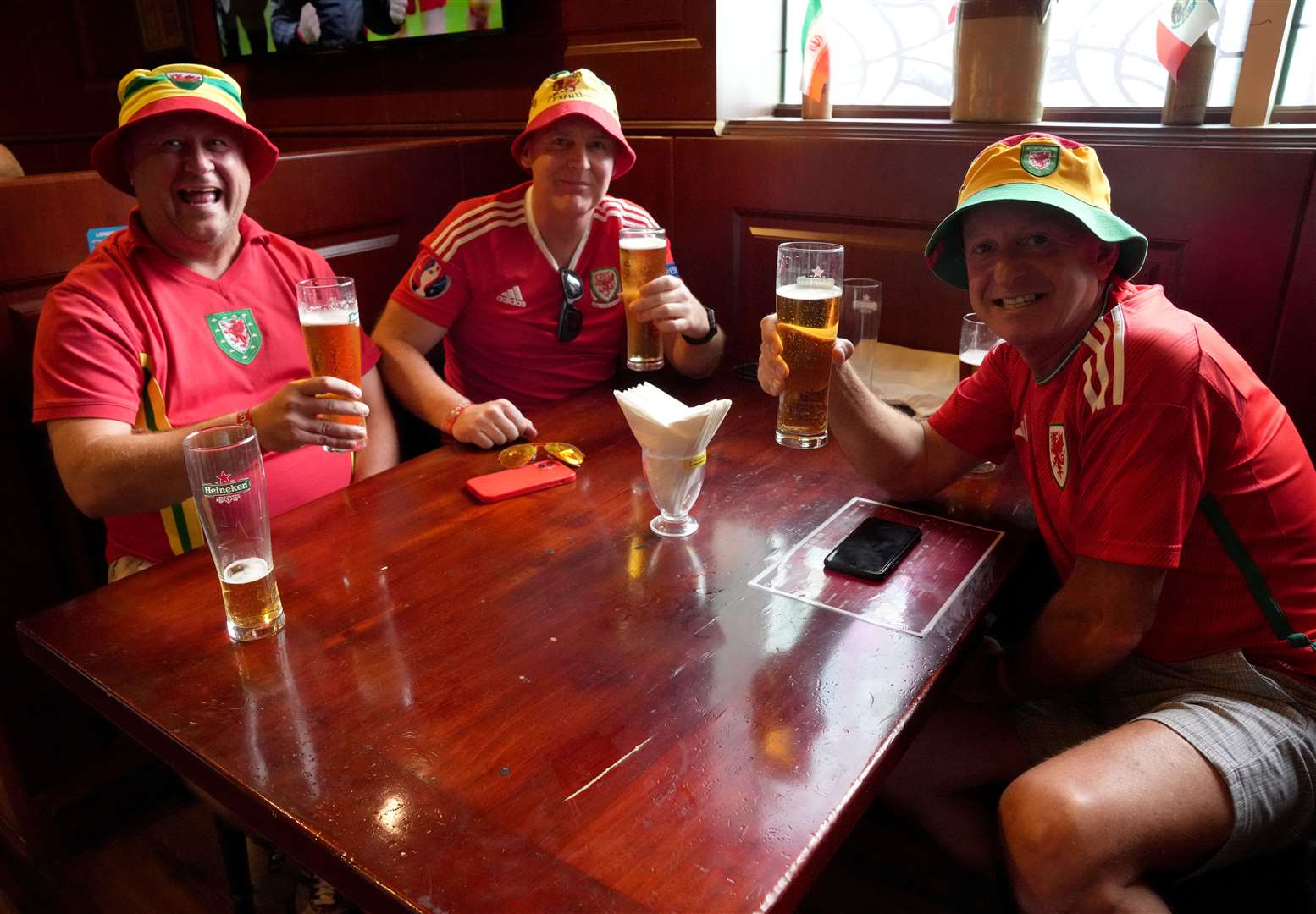 Wales fans Tony Rogers (left), Mike Gristwood (centre) and Steve Pope (right) in the Red Lion Pub & Restaurant in Doha (Jonathan Brady/PA)