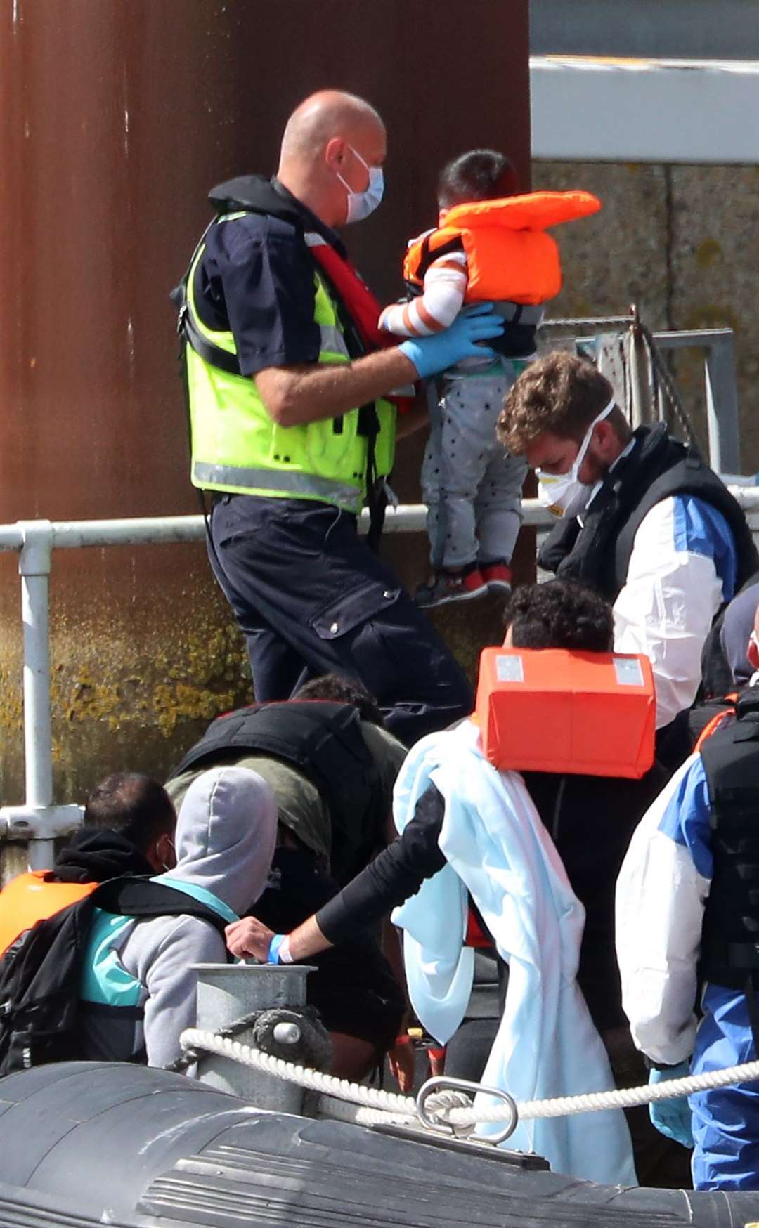 A young boy is carried by a Border Force officer (Gareth Fuller/PA)