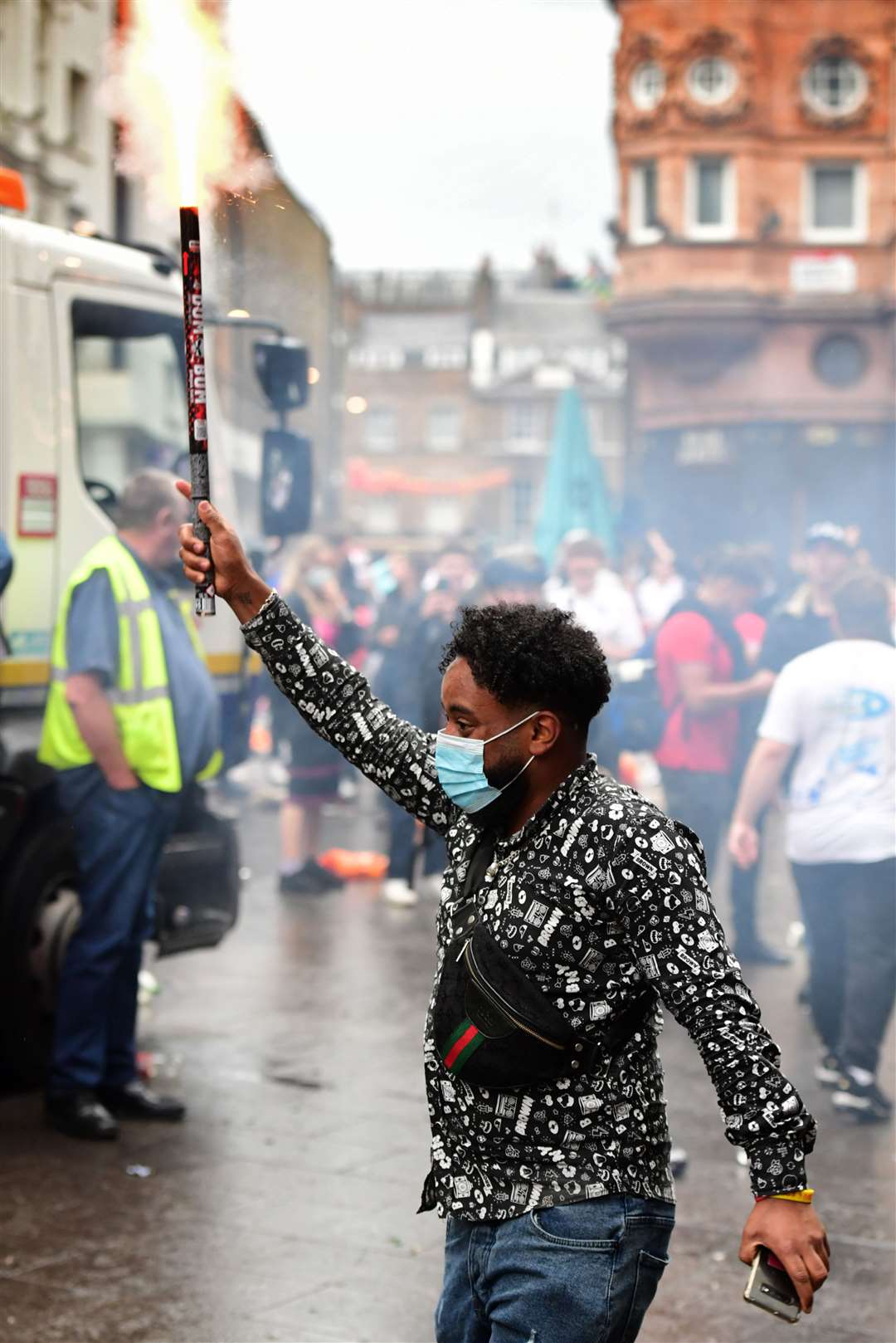 A fan lets off a firework in Leicester Square (Ian West/PA)