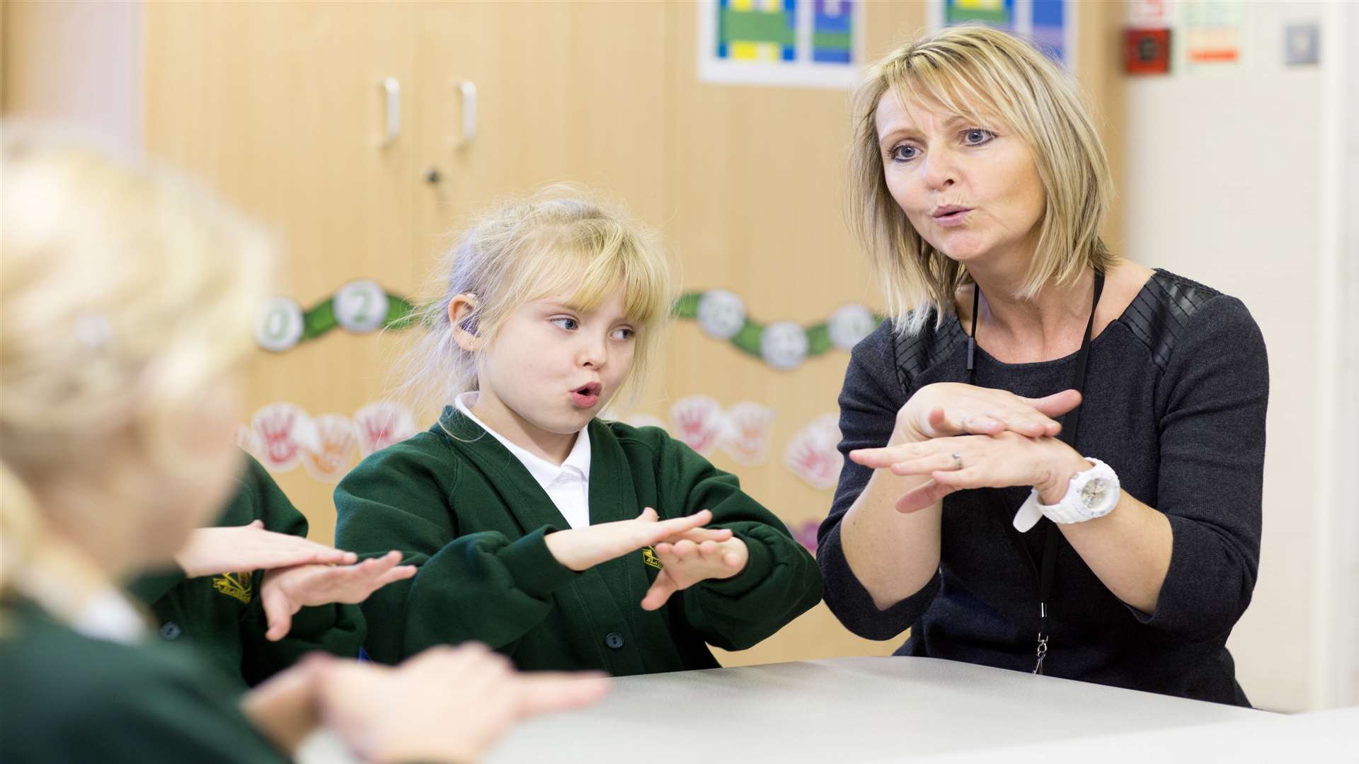 Susie Martin signs with pupils