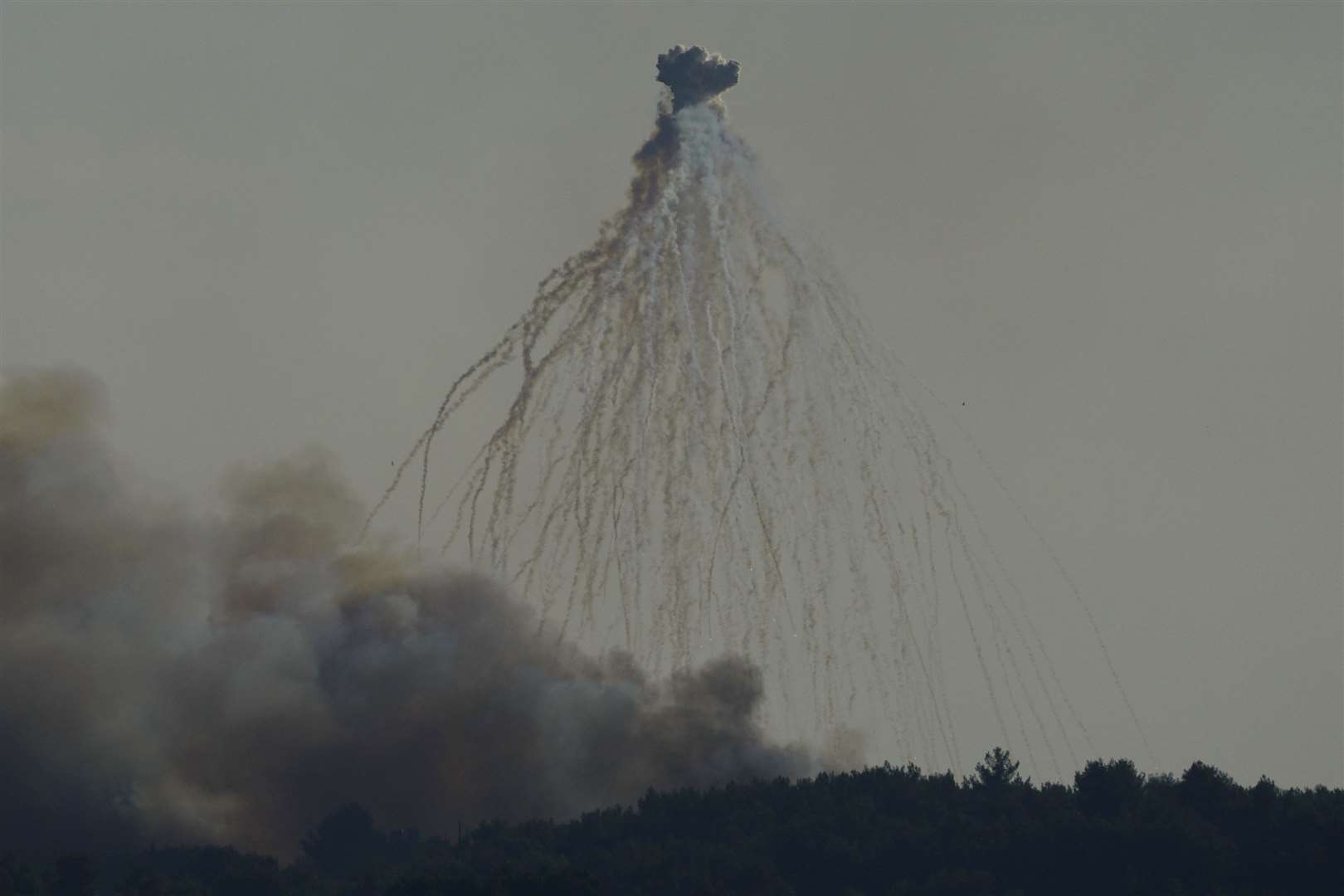 A shell from Israeli artillery explodes over the border line at the Alma al-Shaab border village with Israel, south Lebanon (Hassan Ammar/AP)