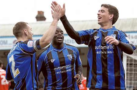 Goalscorer COdy McDonald gets a high five from skipper Barry Fuller as Adebayo Akinfenwa gets ready to join the celebrations