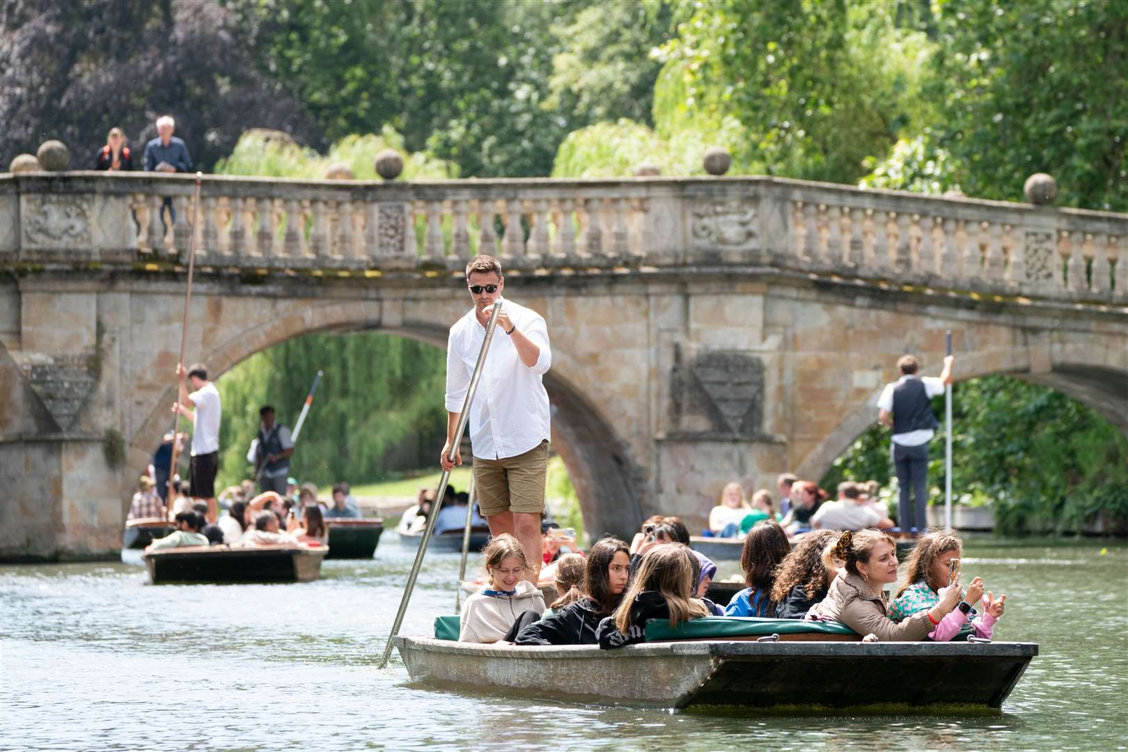 People enjoy a break in the rain showers as they punt along the River Cam in Cambridge (Joe Giddens/PA)