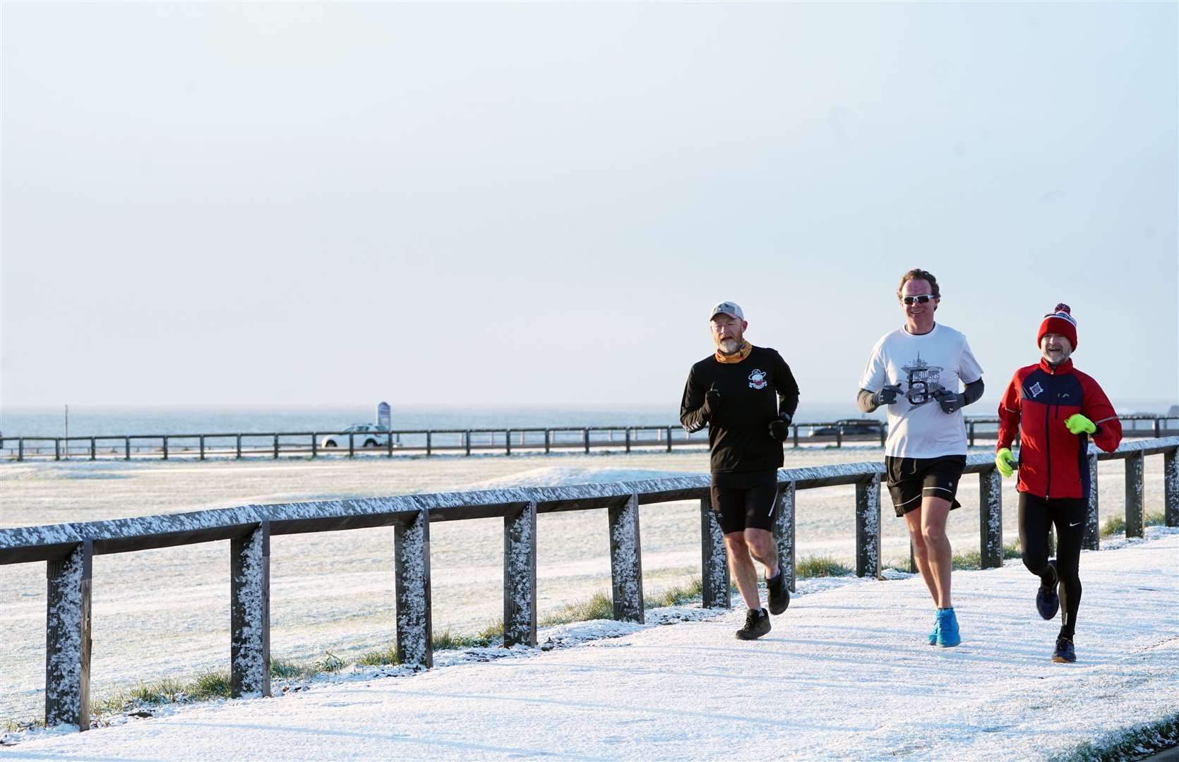 People take exercise in a light dusting of overnight snow at Whitley Bay on the North East coast (Owen Humphreys/PA)