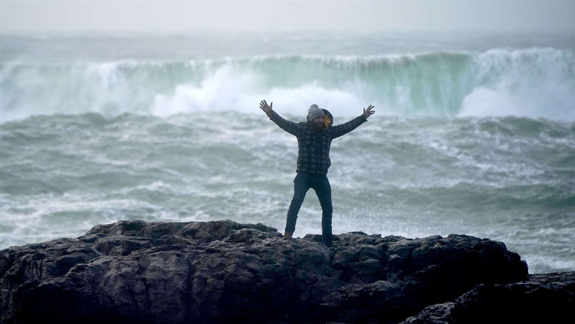 A tourist poses for a photograph on the Burren, near Black Head lighthouse, County Clare (Niall Carson/PA)