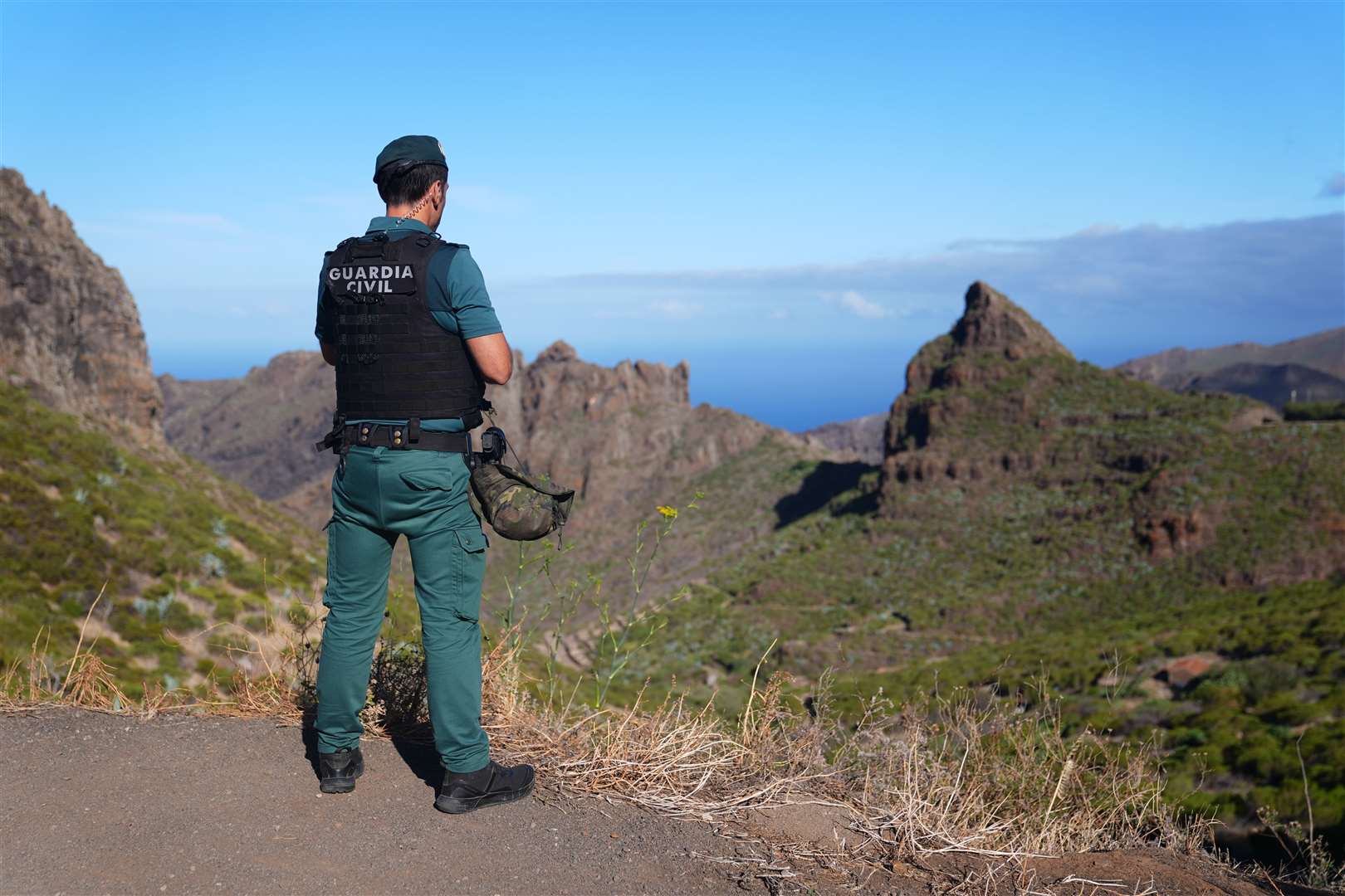 A police officer looks over terrain near Masca in Tenerife (James Manning/PA)