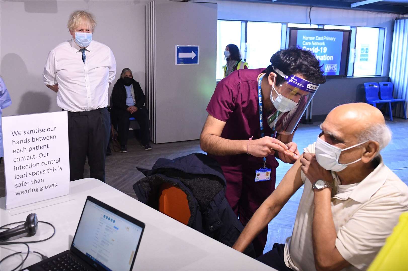 The Prime Minister watches a patient receiving a dose of the vaccine in Barnet where 13,000 jabs have now been administered (Stefan Rousseau/PA)