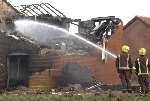 Firefighters dampen down the remains of a house. Picture; Grant Falvey