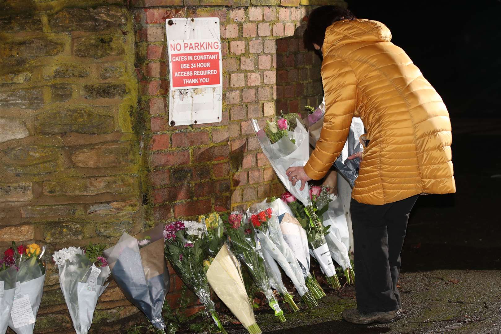 A member of the public leaves a floral tribute outside the home of Captain Sir Tom Moore in Marston Moretaine, Bedfordshire (Yui Mok/PA)