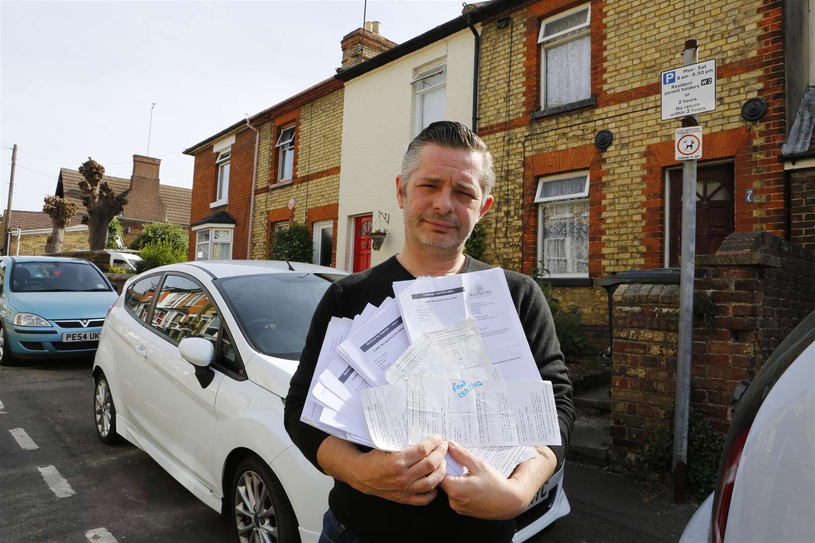 Rob Smith with the mountain of parking tickets he has received for parking outside his house..