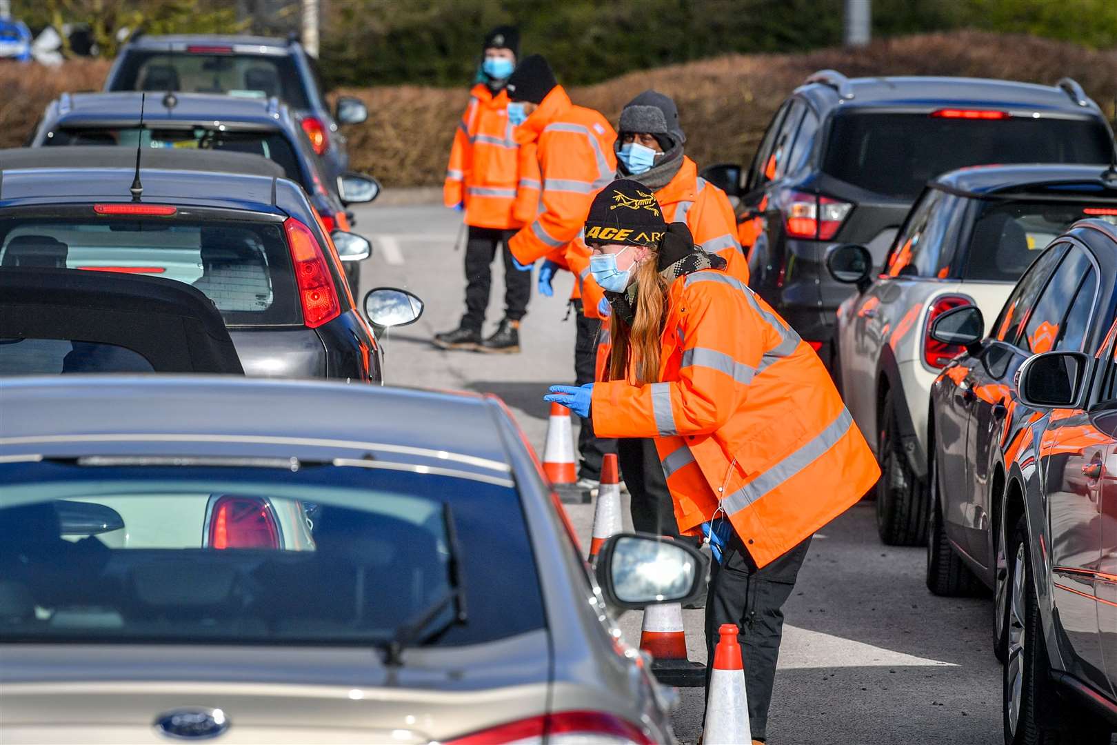 Testing staff hand out kits to motorists attending a surge testing centre (Ben Birchall/PA)