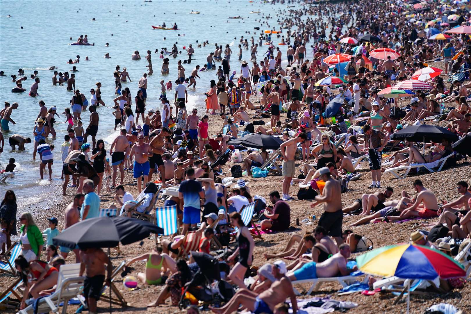 People enjoy the hot weather on Brighton beach in East Sussex (Victoria Jones/PA)