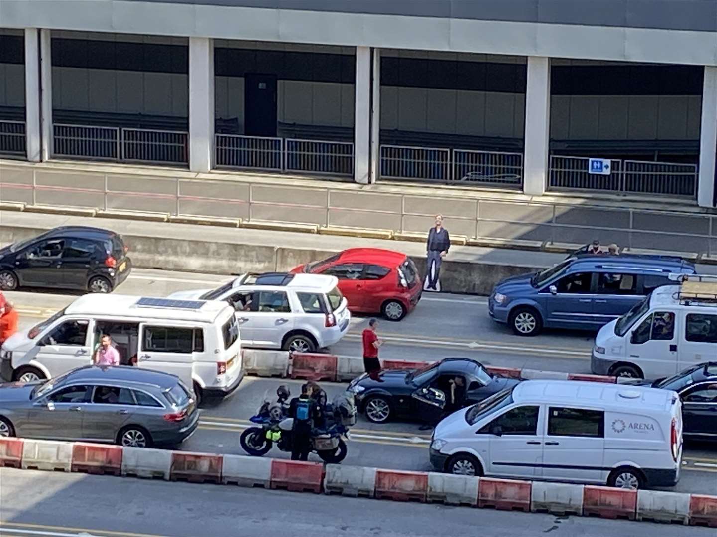 A cutout of Liverpool manager Jurgen Klopp watches on as drivers wait to board