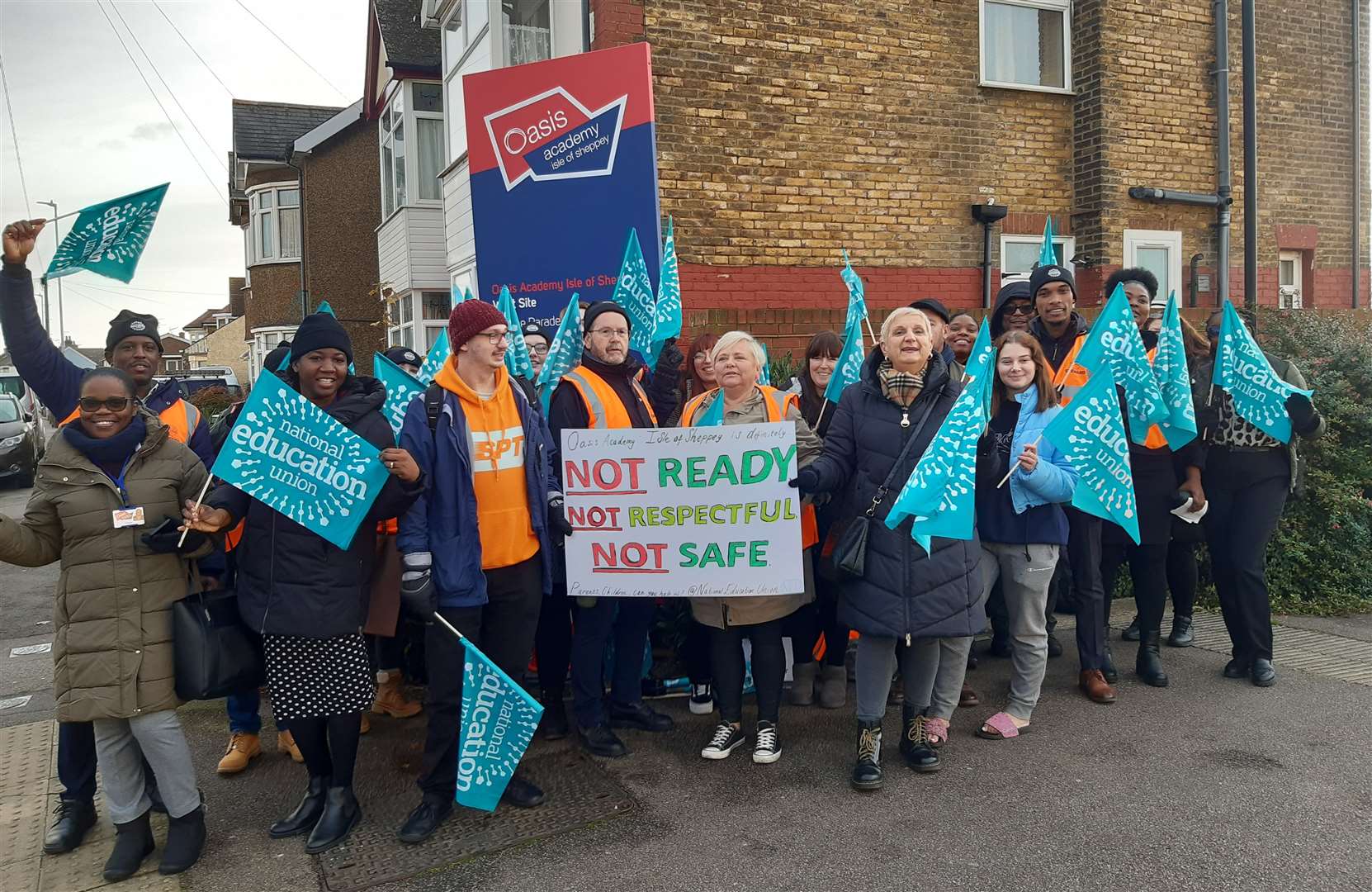 Teachers waving banners and placards on the picket line outside Oasis Academy