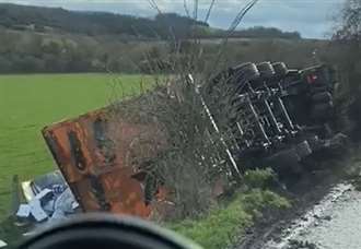 Lorry overturns and crashes onto path