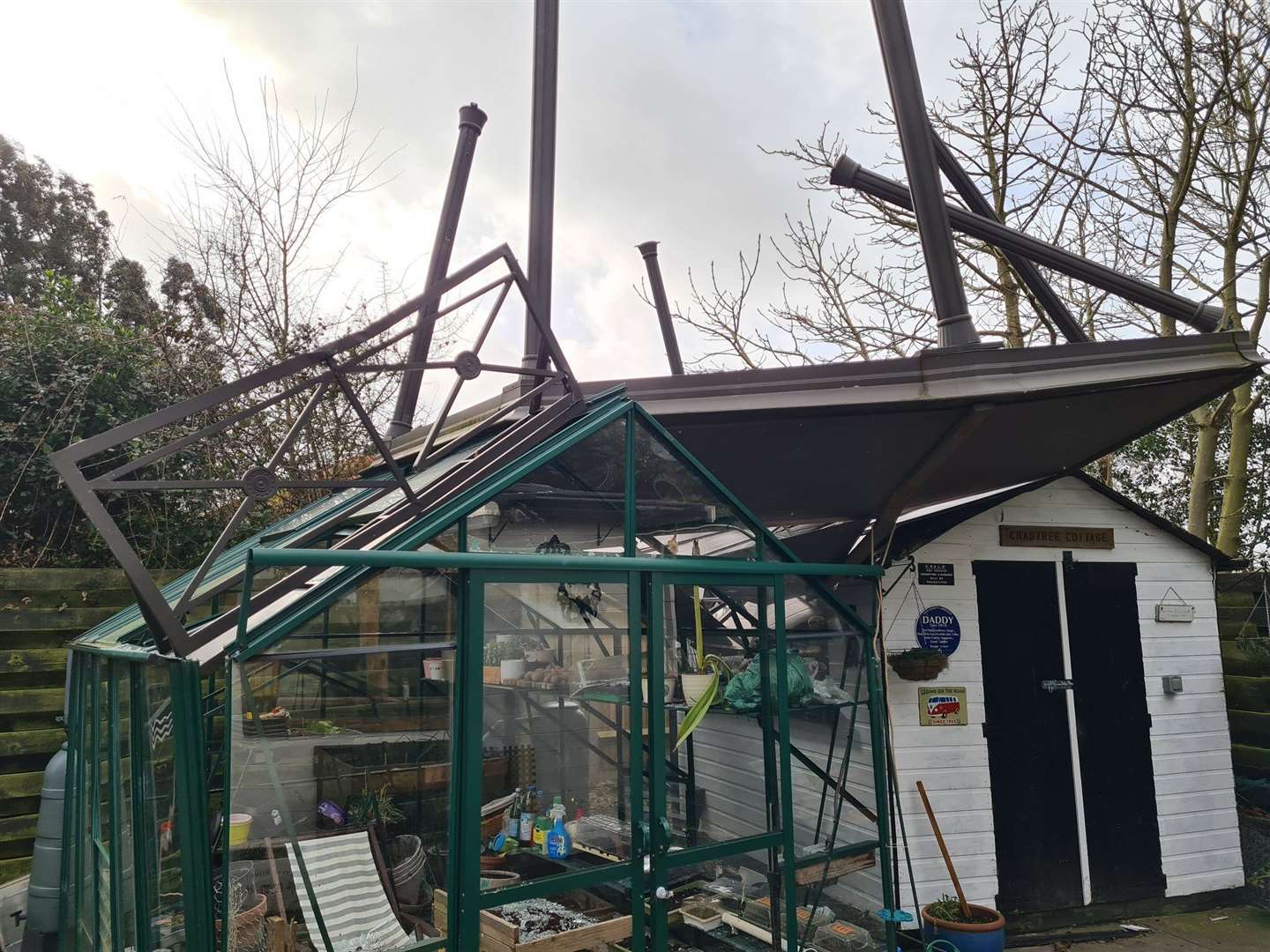 A metal gazebo lands on a shed and greenhouse in Cobham, Surrey (Richard Bull/PA)