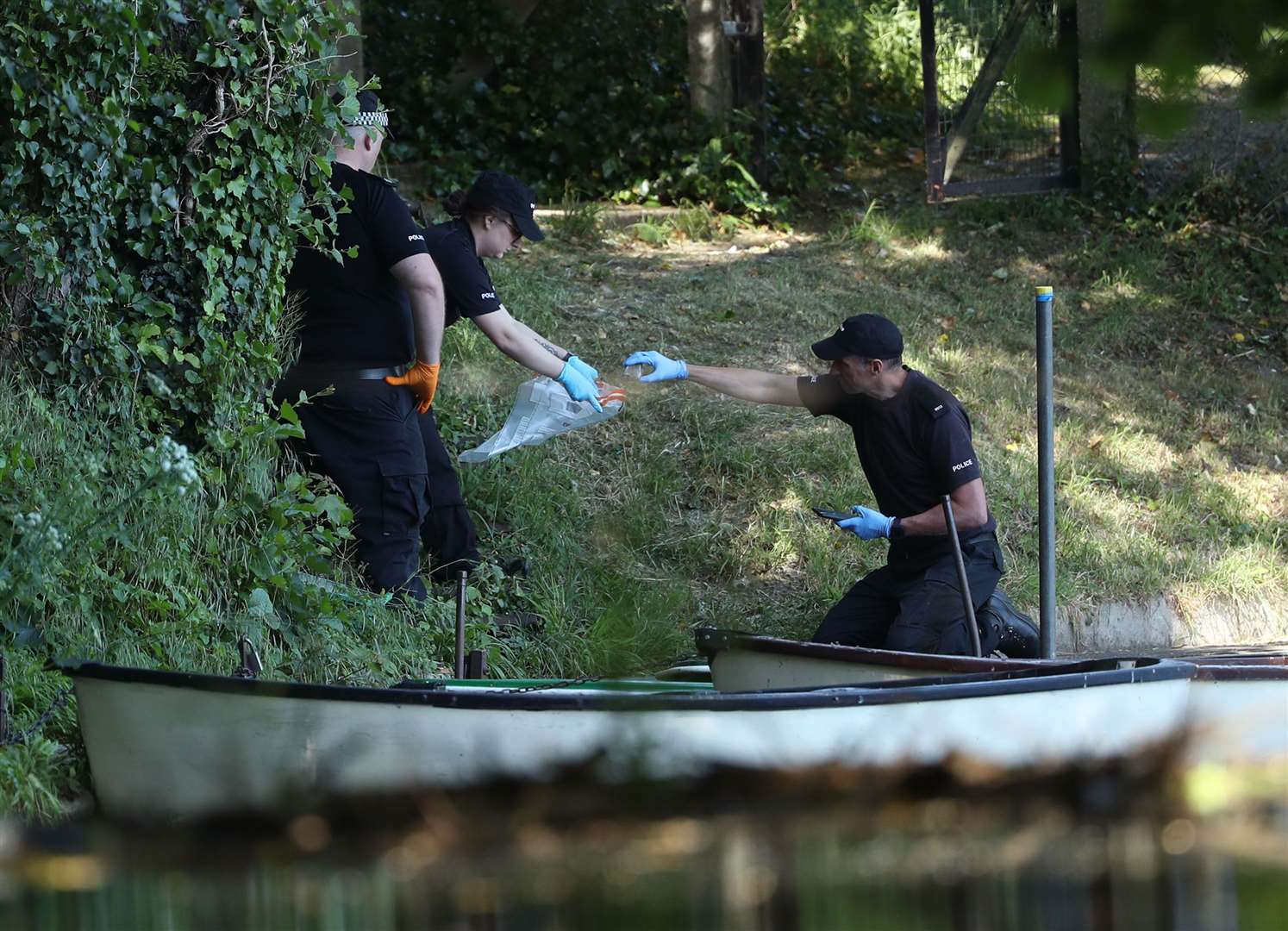 Police forensic officers gather evidence near the boats by the lake in the grounds of Lullingstone Castle in Eynsford, Kent (Yuik Mok/pA)