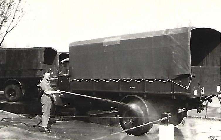 Driver John Marsh of A Platoon, 62 Coy, RASC washing down his Mercedes diesel 4.5 tonne truck in Berlin after making a run delivering loose coal