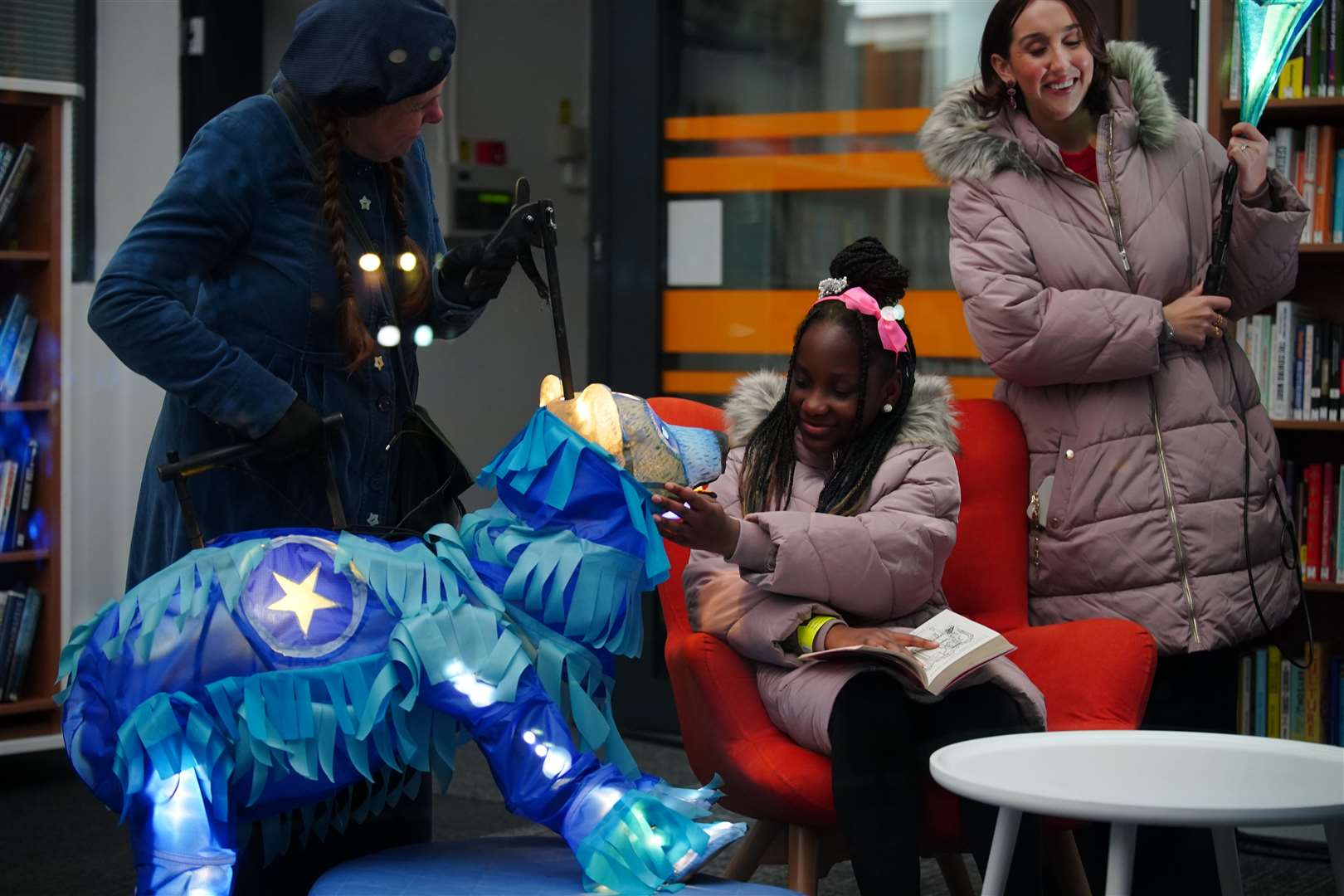 Fundraiser Alex McCormick (right) watches Pearl Ogunyadeka, 10, reading a book inside Spellow Community Hub and Library in Walton (Peter Byrne/PA)